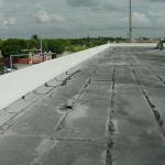 FINISH COAT OF WHITE ELASTOMERIC PAINT  OVER ENTIRE PARAPET WALL OF BUILDING
